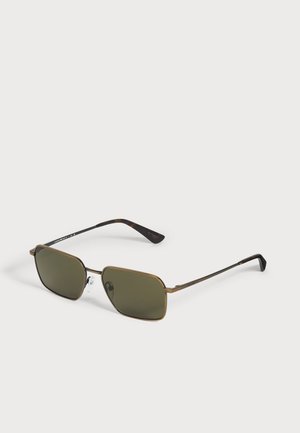 Lunettes de soleil rectangulaires aux verres vert foncé, à la monture fine couleur or et aux embouts de branches noirs, sur fond clair.