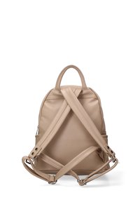 Beige leren rugzak met een ronde vorm, voorzien van gekruiste banden, een klein handvat bovenop en een gestructureerde afwerking.