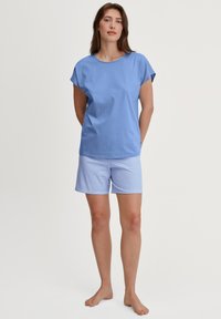 Lichte blauwe T-shirt met korte mouwen van zachte stof, gecombineerd met lichtblauwe gestreepte shorts. Eenvoudig ontwerp, relaxte pasvorm en comfortabele textuur.