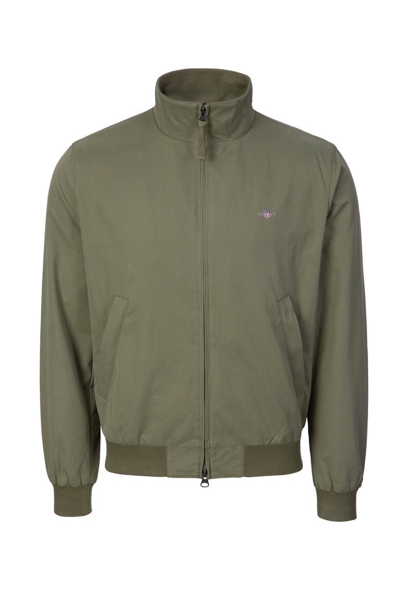 Giacca con zip color verde oliva, collo alto, tasche laterali, polsini elasticizzati e piccolo logo ricamato sul petto a sinistra.