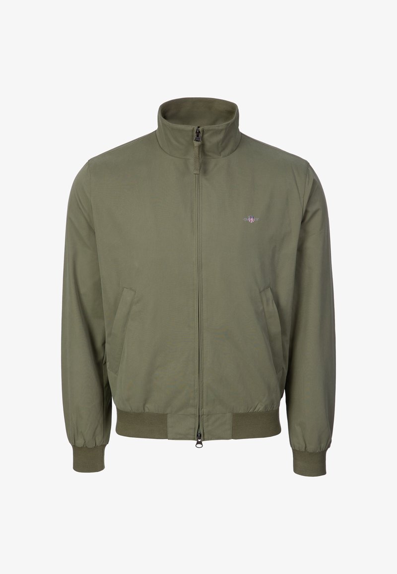 Giacca con zip color verde oliva, collo alto, tasche laterali, polsini elasticizzati e piccolo logo ricamato sul petto a sinistra.