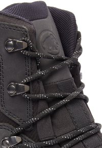 Svart vandringskänga med texturerad tyg, förstärkta öglor och reflexsnören. Har en gummisula och logotypdetalj på sidan.