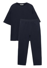 Tmavomodré bavlnené tričko s širokými rukávmi a voľným strihom, skombinované so zodpovedajúcimi zúženými nohavicami s elastickým pásom.