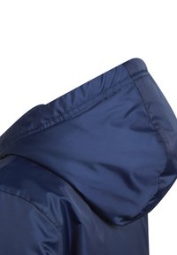 Marineblaue Jacke mit einer strukturierten Kapuze, die eine glatte Oberfläche und geraffte Kanten aufweist. Das Design legt den Fokus auf Funktionalität und Komfort.