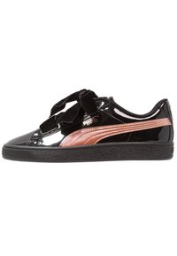 Černá lesklá teniska Puma s hnědým postranním pruhem, černými silnými sametovými tkaničkami a texturovanou černou gumovou podrážkou, zobrazená z vnitřní strany.