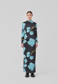 Robe noire longue avec un motif floral turquoise, encolure haute, manches longues et silhouette ajustée. Texture lisse, design jusqu'aux chevilles.