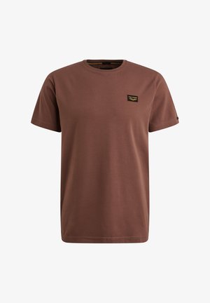 T-shirt en coton marron avec un col rond, des manches courtes et une petite étiquette noire et dorée sur la poitrine gauche. Texture lisse, design simple.