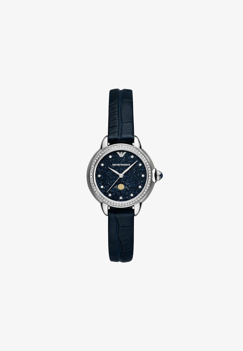 Montre avec bracelet en cuir bleu, boîtier rond en acier argenté, cadran bleu pailleté, accents en cristal et aiguilles argentées, présentant un détail de phase de lune.