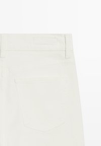 Weiße Jeans aus Denim mit einer Gesäßtasche und einem schlichten Bund. Der Stoff ist weich, mit Nähten entlang der Nähte und einer sauberen Verarbeitung.