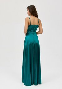Tyrkysová saténová večerní šaty s nastavitelnými tenkými ramínky, přiléhavou korzetovou částí a splývavou sukní, které zdobí hladká textura a detail na zadním zipu.