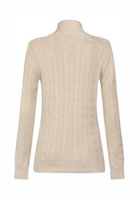 Beige strikket sweater med høj krave, der har et kabelstrik-mønster og lange ærmer, lavet af et blødt, tekstureret stof.