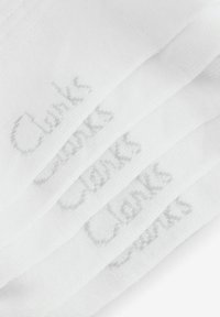 Biały bawełniany materiał z delikatnym szarym logo "Clarks", ułożony w warstwy, prezentujący gładką teksturę i czysty design.