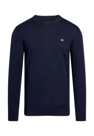 Maglione lavorato a maglia di colore blu navy con maniche lunghe, collo rotondo, polsini e orlo a coste. Presenta un piccolo logo sul petto. Tessuto liscio.