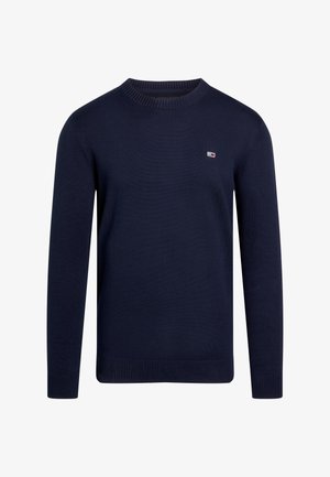 Maglione lavorato a maglia di colore blu navy con maniche lunghe, collo rotondo, polsini e orlo a coste. Presenta un piccolo logo sul petto. Tessuto liscio.