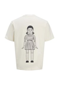 Camiseta blanca de algodón con un estampado gráfico de una muñeca con un vestido, coletas y medias hasta las rodillas en la parte posterior. Cuello redondo, mangas cortas.