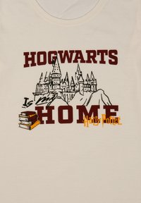 Schizzo del castello di Hogwarts con il testo "Hogwarts è la mia casa", illustrazione di libri impilati e logo di Harry Potter su sfondo di tessuto beige.