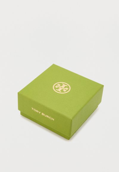 Boîte en carton verte avec un logo doré sur le dessus et "TORY BURCH" imprimé en doré sur le côté. De forme carrée avec une texture lisse.