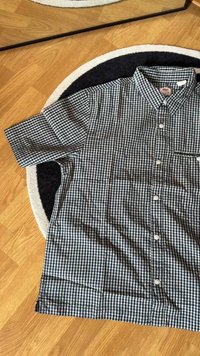 Chemise à manches courtes, col, en motif vichy bleu marine et blanc. Boutonnage sur le devant et petite poche sur le côt�é gauche du poitrail.
