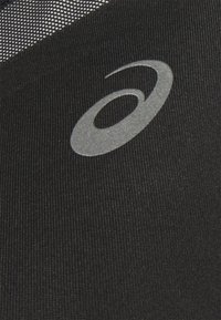 Țesătură neagră cu o suprafață texturată, având un logo gri reflective. Designul este elegant, punând accent pe materiale orientate spre performanță.
