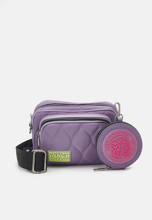 Bolso bandolera acolchado en morado con dos compartimentos con cremallera, correa negra ajustable y monedero redondo con el logo rosa de "River Island".
