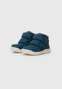 Baskets montantes en cuir suédé bleu avec deux sangles réglables en Velcro, semelles en caoutchouc blanches et doublure intérieure douce. Présente le logo de la marque sur le côté.