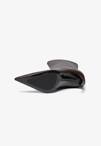 Brown leather heeled boot with a pointed toe and a sleek design. Smooth texture with a contrasting black sole and minimal detailing on the shaft.