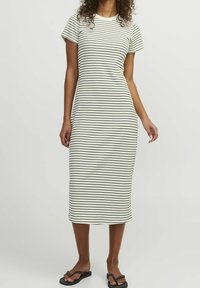 Robe midi rayée en crème avec des rayures horizontales noires, présentant des manches courtes, un col rond et une silhouette ajustée.