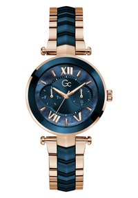 Orologio da polso rosa gold con quadrante blu navy, numeri romani e due sottodial. Presenta un bracciale testurizzato con link metallici e blu navy alternativi.