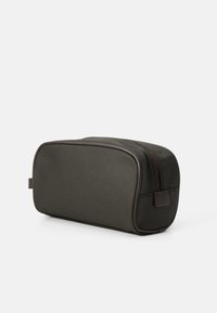 Necessaire retangular verde escura com bordas arredondadas e detalhes em marrom, apresentando um fecho éclair no topo e uma pequena alça lateral.