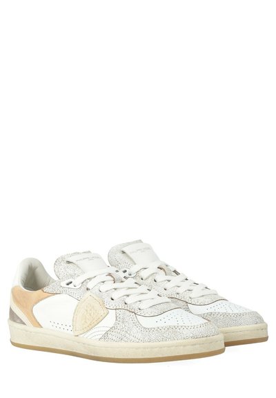 Sneakers bianchi con tomaia texturizzata, dettagli in pelle liscia, pannello laterale beige chiaro, lacci piatti e suola in gomma beige. Design atletico classico.