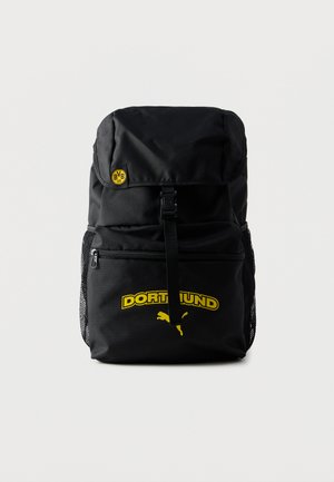 Sac à dos noir en tissu résistant, doté d'un rabat supérieur, d'une boucle ajustable, du logo jaune "DORTMUND" et de poches latérales en maille.