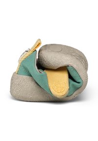 Chaussure molle pliée pour tout-petit avec semelle grise texturée, dessus en tissu bleu sarcelle et bride velcro jaune sur fond blanc.