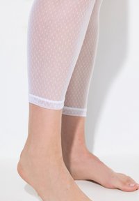 Legging en maille blanche avec un motif texturé à pois, coupé au mollet, doté d'une douce ceinture élastique et d'une bordure opaque en bas.