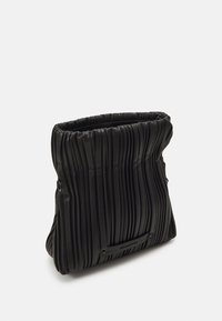 Borsa a pieghe nera realizzata in materiale testurizzato. Caratterizzata da un'apertura cinchata e una base liscia. Hardware minimale con un sottile dettaglio del logo.