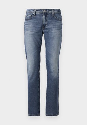 Keskmise sinise värvuse denim teksad, sirge jala disainiga, õrna tuhmumisega ja klassikalise viie tasku stiiliga. Metallist komponentide detailid vööl ja taskutel.