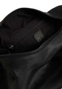 Melnas ādas soma ar teksturētu virsmu. Iekļauj rāvējslēdzēja atvēršanu, iekšējo nodalījumu ar atsevišķu rāvējslēdzēju kabatu un auduma oderi.