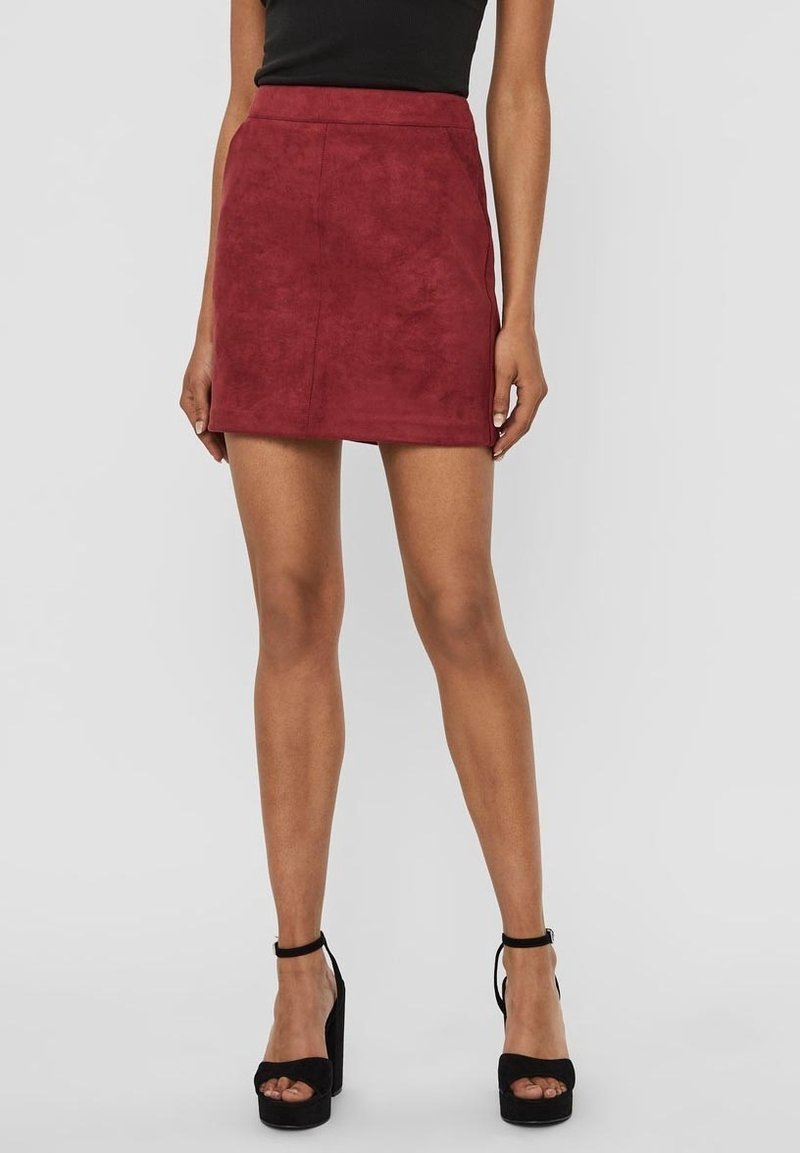 Bordeaux suède minirok met een aansluitend ontwerp, hoge taille en een zachte structuur, gecombineerd met zwarte plateau sandalen.
