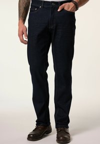 Tumma sininen farkkukangas, jossa on suora lahjetyyli, kontrastiväriset ompeleet, sivutaskut ja perusnapitus vyötäröllä.