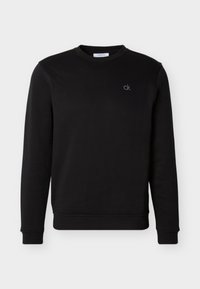 Μαύρο φούτερ μακρυμάνικο με στρογγυλή λαιμόκοψη και μικρό λευκό λογότυπο «ck» κεντημένο στο αριστερό μέρος του στήθους, με ριμπ μανσέτες και τελείωμα.