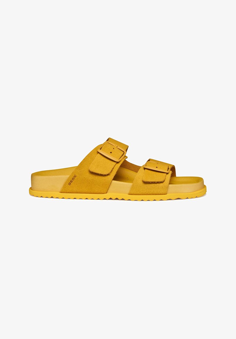 Sandale mule en daim jaune avec deux brides réglables à boucle et une semelle texturée, conçue pour un usage décontracté.