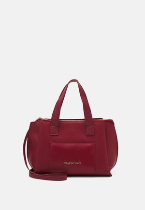 Red leather handbag with a textured finish, featuring two short handles and an adjustable shoulder strap. Gold logo accents on the front.