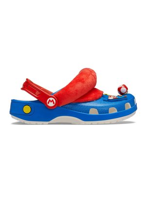 Sabot bleu à enfiler avec bride réglable rouge, languette en peluche rouge et décorations sur le thème de Super Mario comprenant un champignon et un pendentif personnage.
