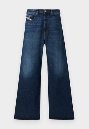 Weite, dunkle Denim-Jeans mit hohem Bund. Mit fünf Taschen, einem Knopfverschluss und einem abgeriebenen Finish near den Oberschenkeln.