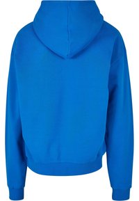 Hanorac albastru cu glugă, cu o croială lejeră, având o textură netedă și manșete și tiv cu model în buclă. Design simplu, fără modele sau accente vizibile.