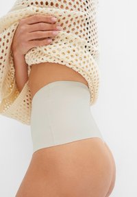 Shapewear taille haute couleur chair fabriqué à partir d'un tissu lisse et extensible. Possède un design sans couture avec une finition douce et mate.