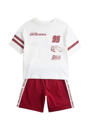 Biała koszula z krótkim rękawem z czerwonymi paskami i grafiką Zygzaka McQueena, w zestawie z czerwonymi szortami z napisem McQueen na bocznych panelach.