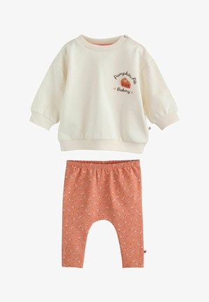 Creme langærmet babytop med "Pumpkin Pie Bakery" og tærte grafik, parret med orange blomsterprintede elastikbukser.