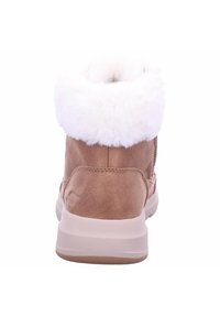 Bottines en suède marron avec un col en fausse fourrure blanche, semelle rembourrée et finition texturée. Présente un logo subtil au niveau du talon.