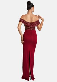 Rode avondjurk met een off-the-shoulder pailletten lijfje, een strakke pasvorm, een hoge split tot het bovenbeen en een gladde stofstructuur.
