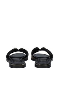 Sandalias deslizantes negras con suela plana, que presentan un acabado suave, diseño de punta abierta y una correa minimalista. Acento dorado a lo largo de la suela.